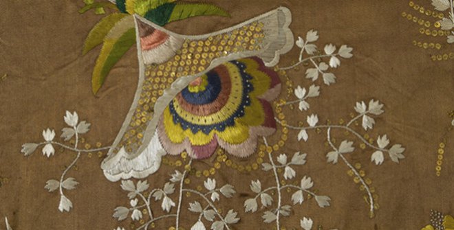 Detalle de vestido en raso de seda, ca. 1790. Una aplicación de bordado en seda lasa y lentejuelas que dibujan un motivo floral.
