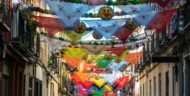 Calle de Madrid decorada con mantones y guirnaldas durante las fiestas de agosto
