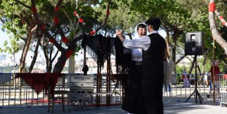 Pareja vestida con los trajes tradicionales madrileños bailando un chotis en los Jardines de las Vistillas