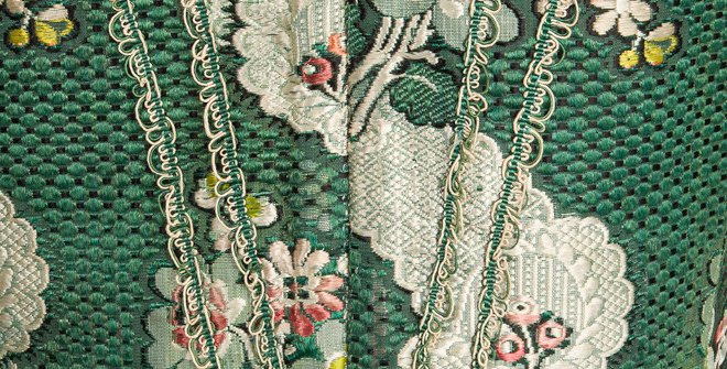 Detalle de la espalda de jubón, ca. 1750, en brocatel de seda de color verde decorada con motivos florales polícromos.